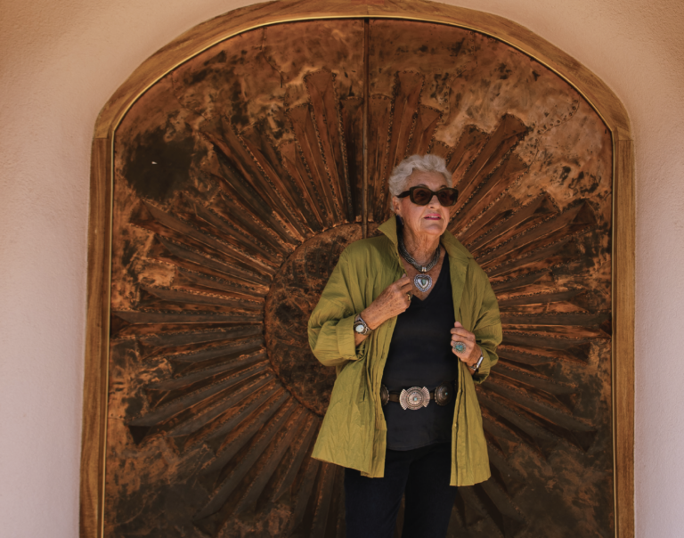 Evelyne Boren, painter and Bond girl, stands in a green jacket in front of a wooden door